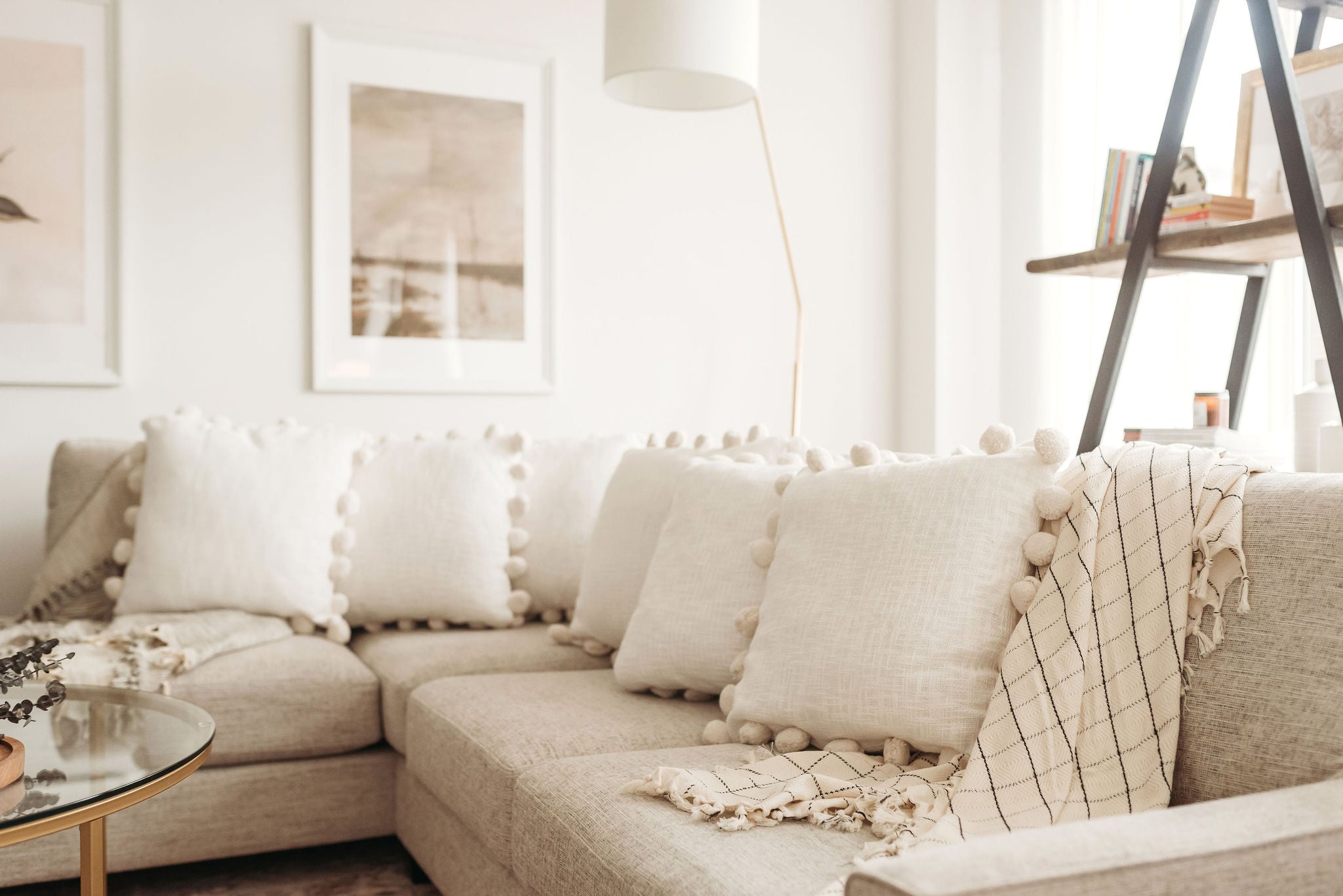 Five POM POM throw pillows on a sofa