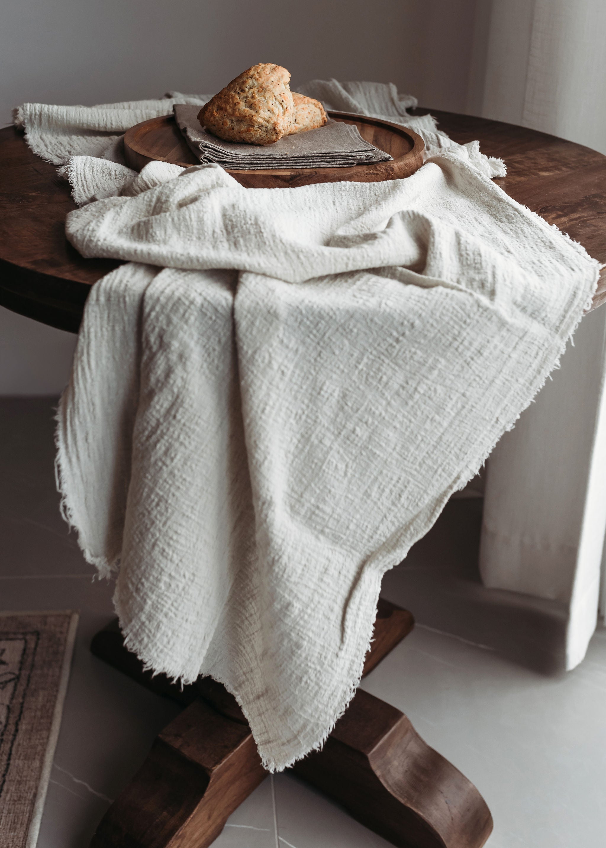 Cloth table runner cascading down a wooden table.